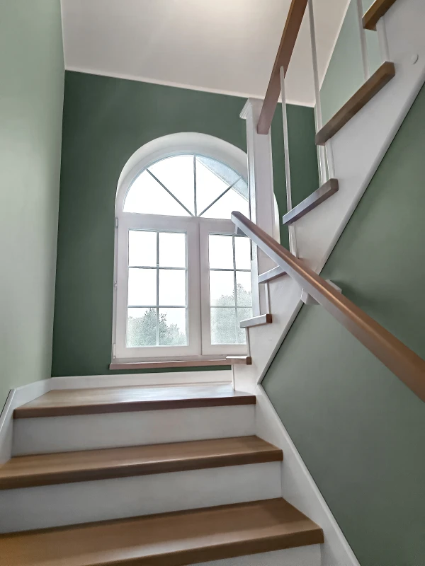 Schody jesionowe dwubiegowe z dekoracyjną balustradą