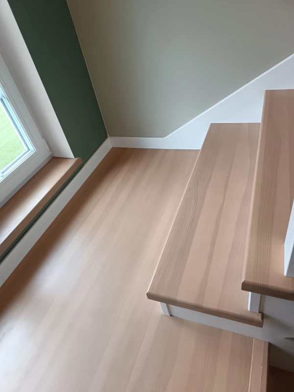 Schody jesionowe dwubiegowe z dekoracyjną balustradą